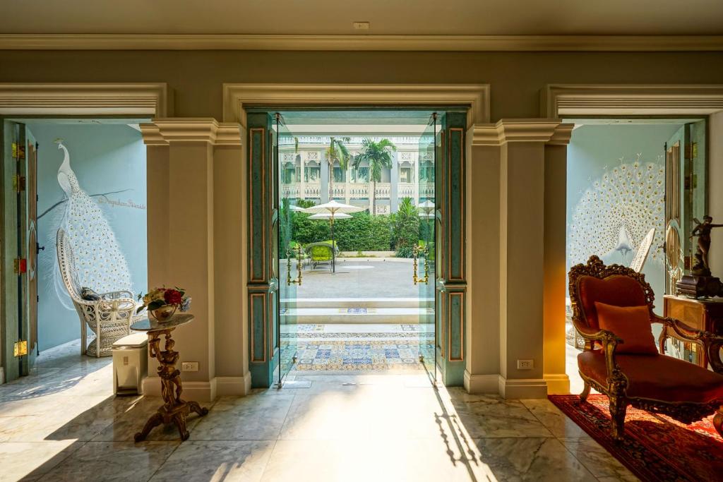 A marble hallway opens directly onto the garden courtyard through ornate doorways.