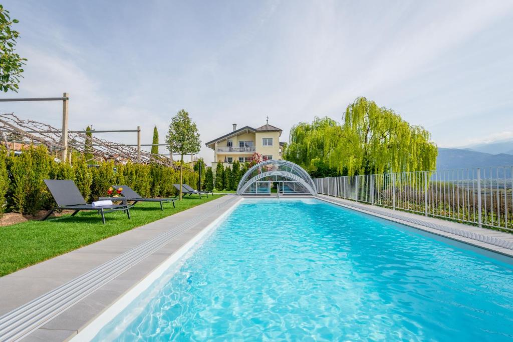een zwembad in de achtertuin van een huis bij Quellenhof in Termeno