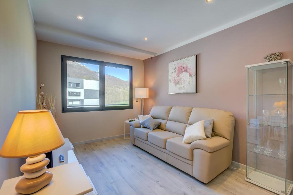 ein Wohnzimmer mit einem Sofa und einem Fenster in der Unterkunft 4 Seasons Apartment - Happy Rentals in Taverne