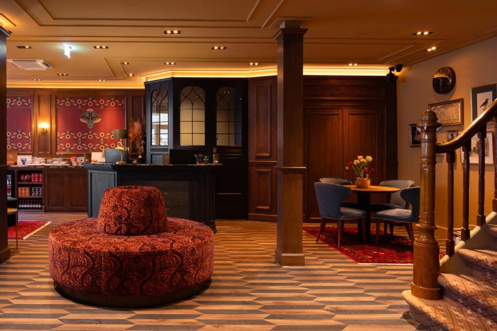 een lobby met een poef in het midden van een kamer bij Hotel Aalders in Amsterdam