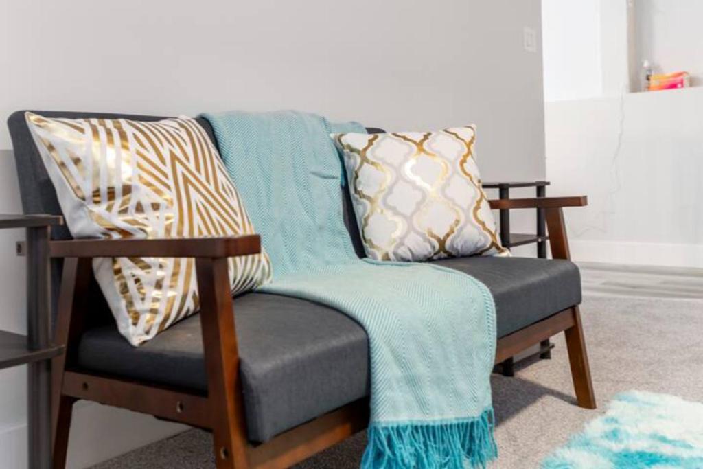 una silla con almohadas en la sala de estar en Furnished rooms close to U of A in Edmonton, en Edmonton