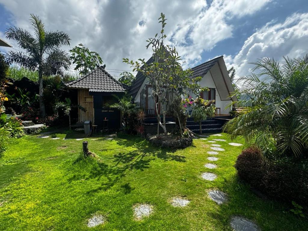 a house with a grass yard with a house at Belvilla 93878 Private Room In Kintamani Near Toya Devasya in Kintamani