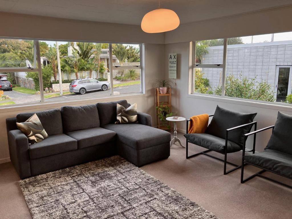 a living room with a couch and two chairs at Townhouse on Courtenay in New Plymouth