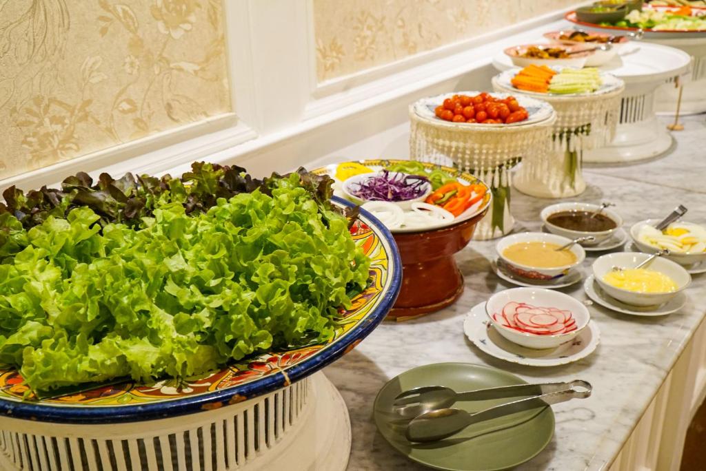 A salad and vegetable station offers leafy greens, sliced vegetables, and dressings.