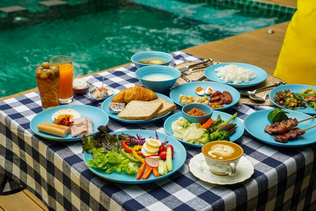 A poolside table is set with a broad selection of breakfast dishes and drinks.