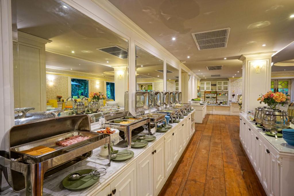 A central buffet island runs through an ornate dining room with serving stations on both sides.