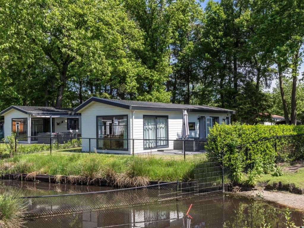 a house on the side of a river at Chalet by the Pond with Modern Comfort in De Bult
