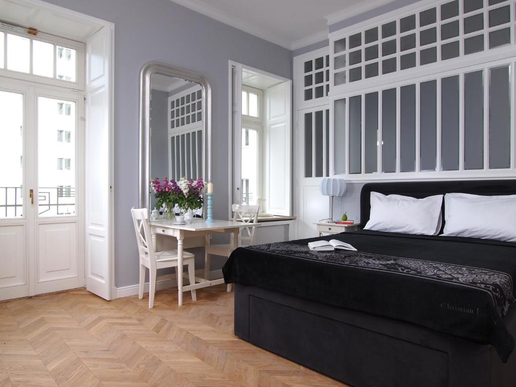 a bedroom with a black bed and a table with a tableasonable at Warsaw Concept in Warsaw