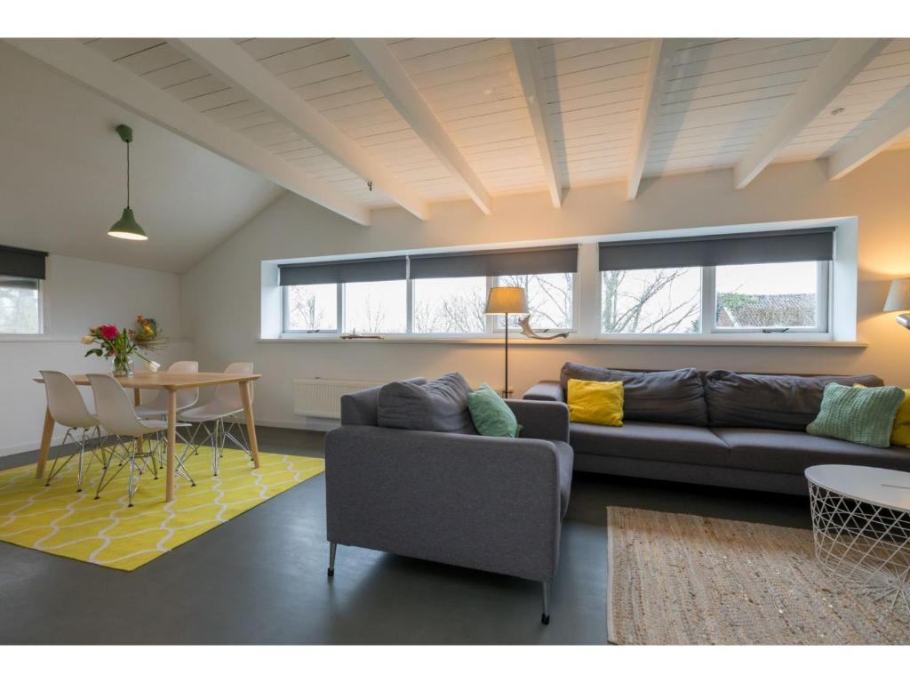 een woonkamer met een bank en een tafel bij Superb apartment near the beach in Vrouwenpolder in Vrouwenpolder
