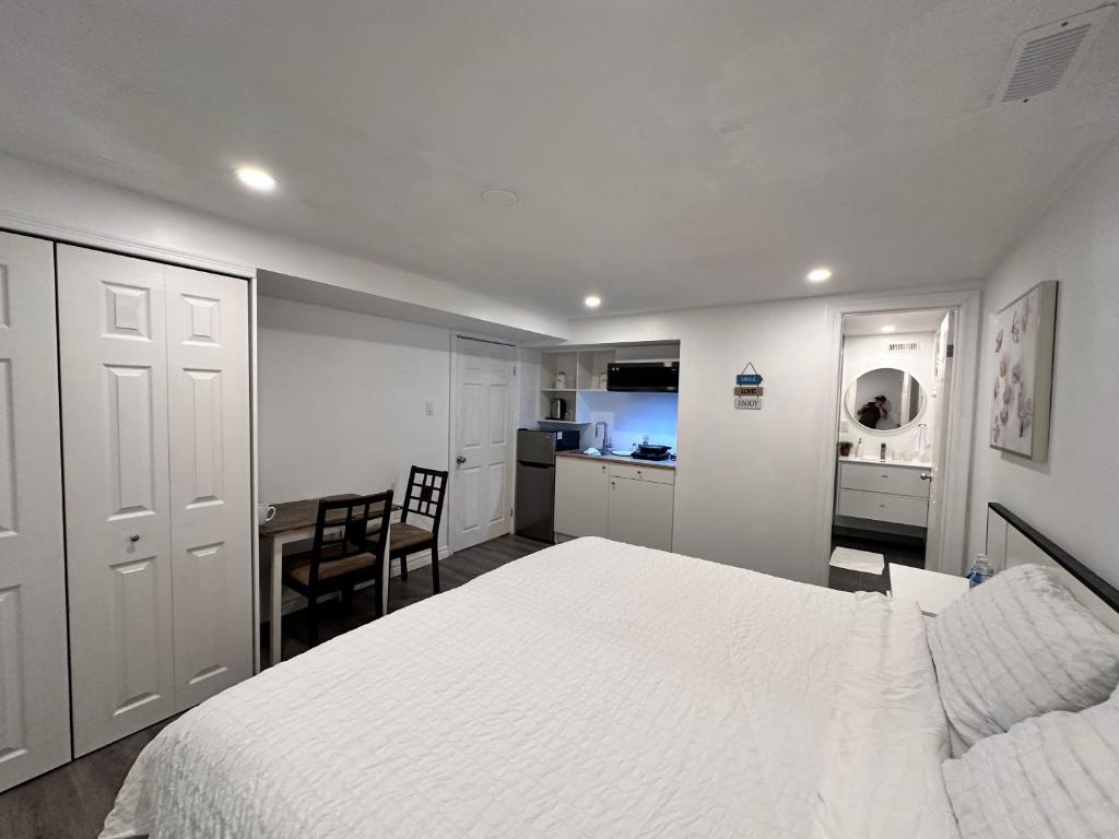 een slaapkamer met een wit bed en een keuken bij Riverwood Home in Mississauga