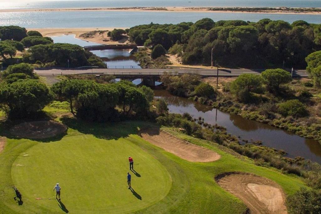een uitzicht op een golfbaan naast het water bij Adosado en Hoyo 14, junto al campo de golf Nuevo Portil NP14442 in El Portil