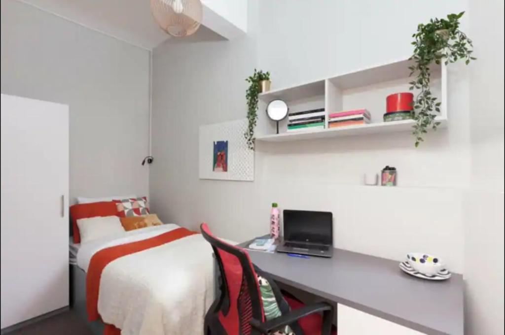 a bedroom with a bed and a desk with a computer at Private room in rental unit in London