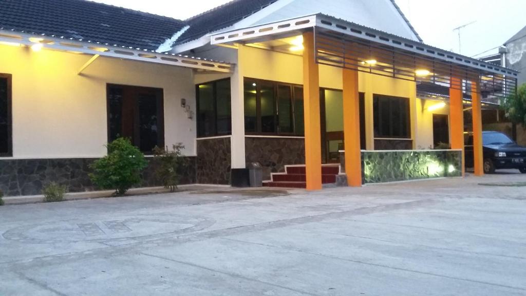 un edificio giallo e bianco con parcheggio di Yokima Beach Hotel a Pangandaran