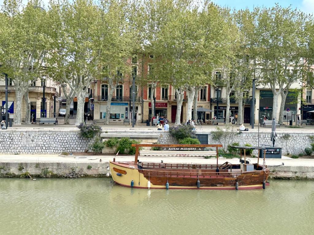 un bateau assis dans l'eau à côté d'un bâtiment dans l'établissement Le Victor Hugo de la Robine, à Narbonne
