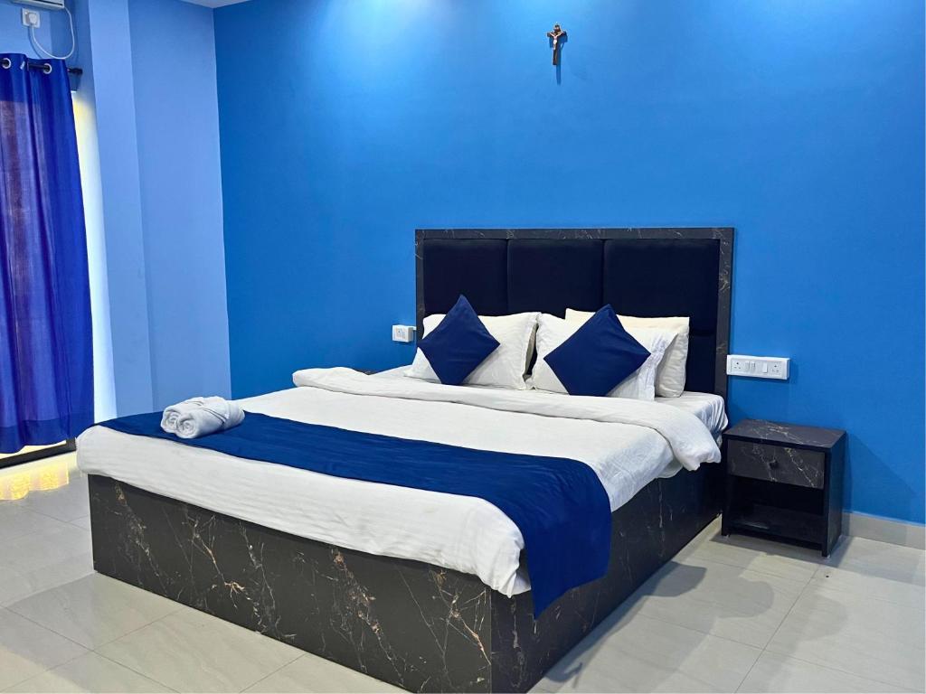 a blue bedroom with a large bed with blue walls at Hotel Downtown Calangute in Calangute