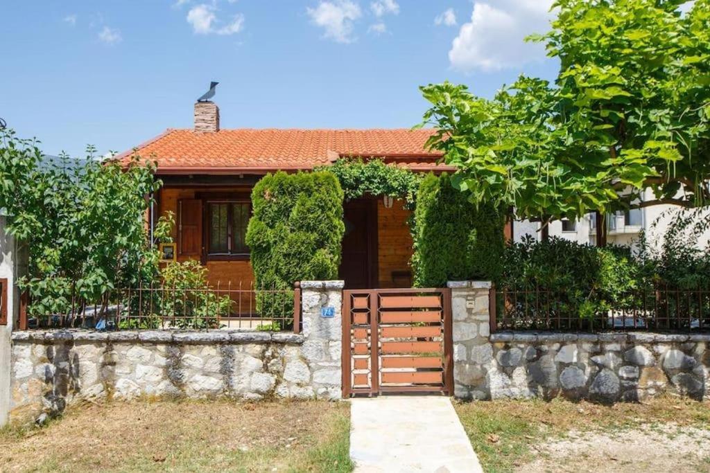 a house with a wooden gate and a stone fence at WOODEN HOUSE IN IOANNINA in Ioannina