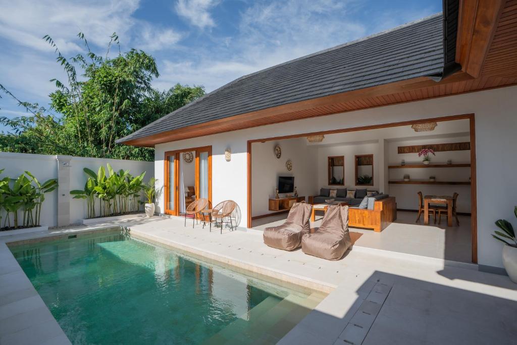 a house with a swimming pool and a patio at Kubu Dimel Suites and Villas Resort in Nusa Dua