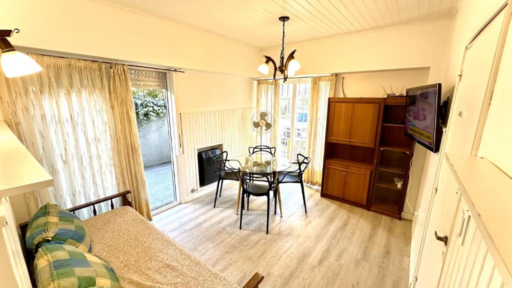 uma sala de estar com uma mesa e uma sala de jantar em Cálido dpto de 2 ambientes con parrilla y cochera en zona residencial de Punta Mogotes em Mar del Plata