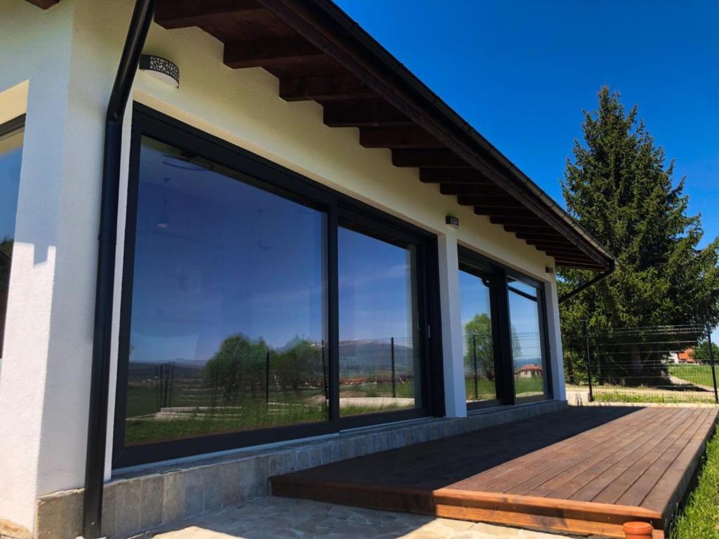 Casa con ventanas grandes y terraza de madera. en Gerana Belchin en Belchin
