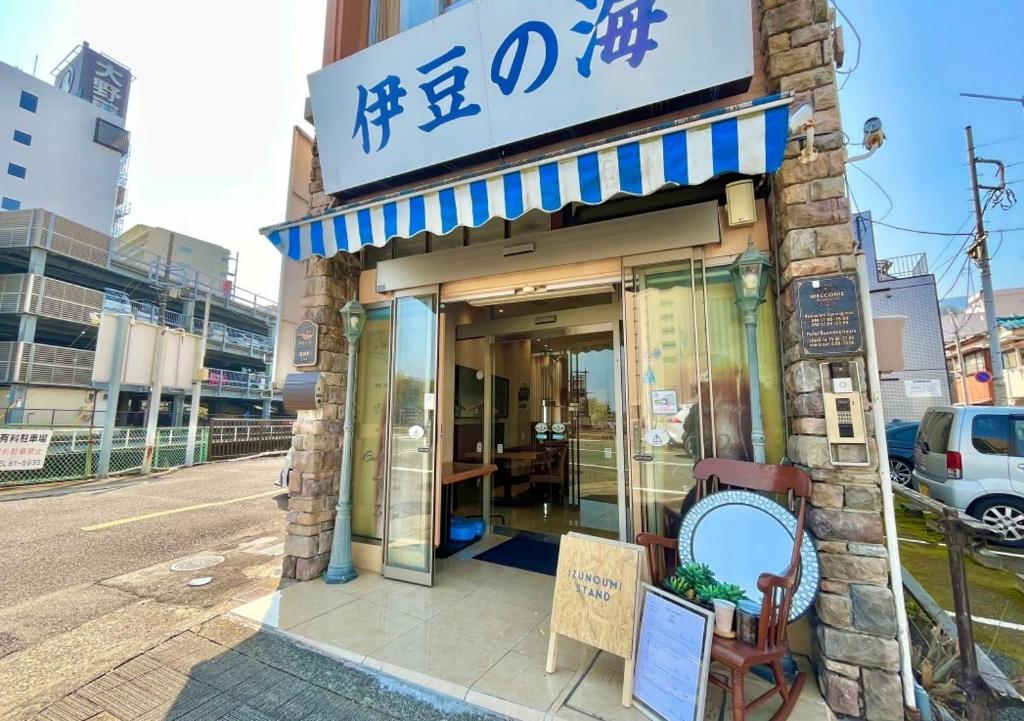 a building with a sign on the side of a street at Hostel and Cafe izu-no-umi in Atami