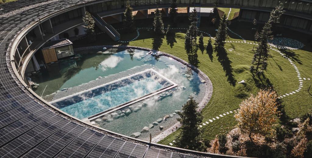 een uitzicht over een zwembad met bomen bij OLM Nature Escape - Eco Aparthotel in Campo Tures