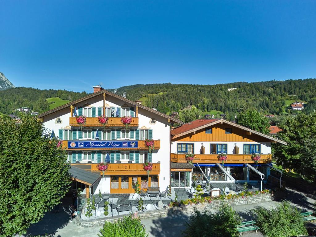 een gebouw met bloemen op de balkons bij Alpenhotel Rieger in Mittenwald