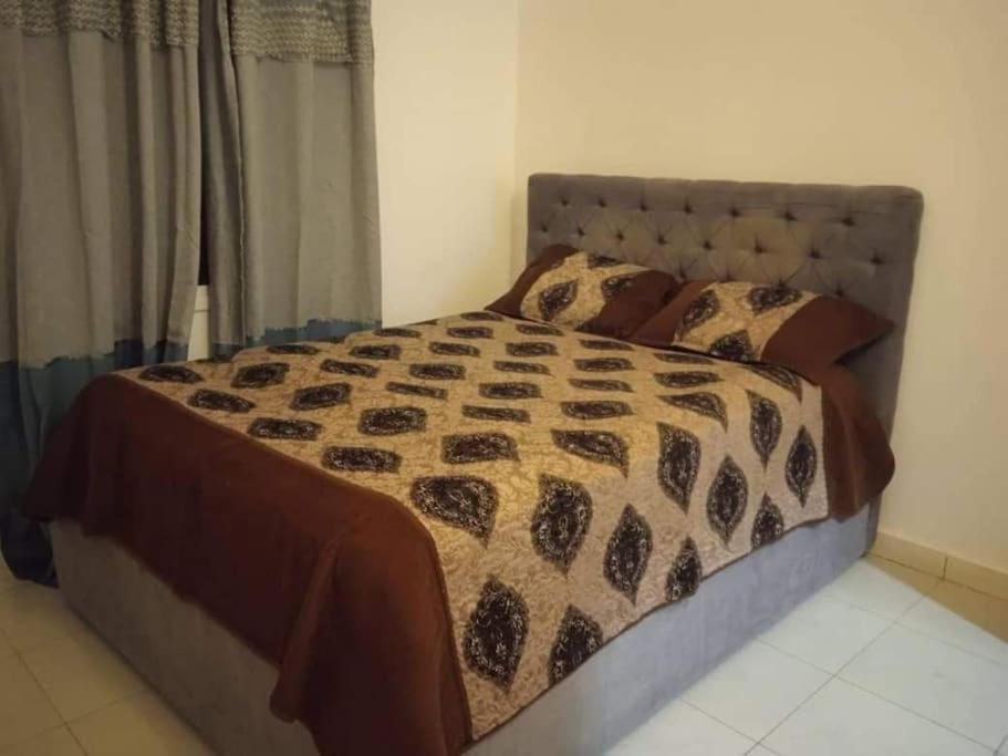 a bedroom with a bed with a comforter and pillows at 3 bedroom, free Wi-fi, Aircon & Hot water in Tujering