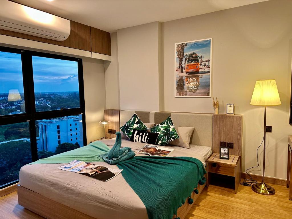 Un dormitorio con una cama grande con una ventana grande. en Astra Sky River Paronama Pool Luxury Changklan Chiang Mai, en Chiang Mai