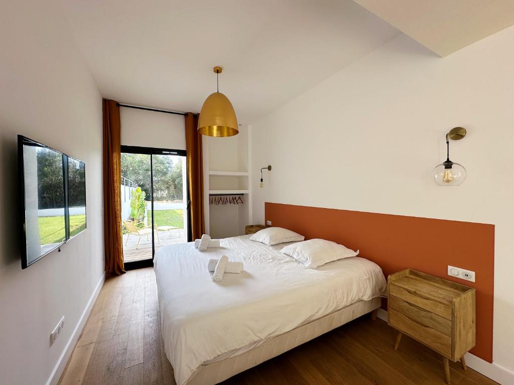 a bedroom with a large bed and a large window at Villas de standing avec magnifique vue mer et piscines privées, Sagone in Sagone