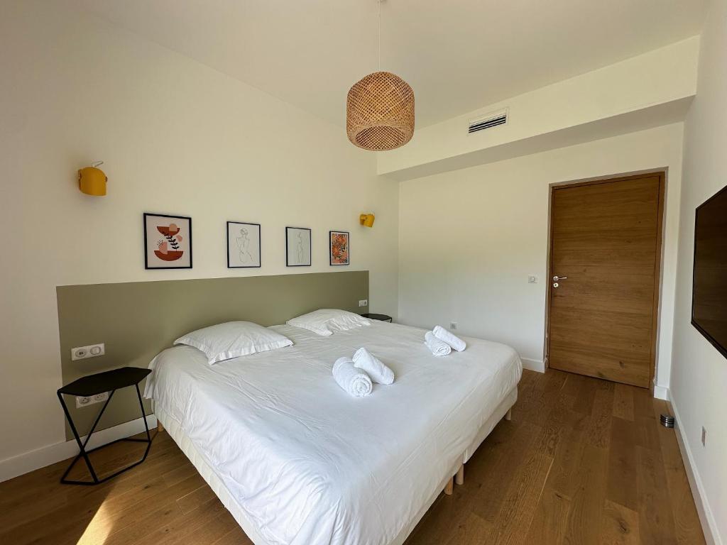 a bedroom with a large white bed with towels on it at Villas de standing avec magnifique vue mer et piscines privées, Sagone in Sagone
