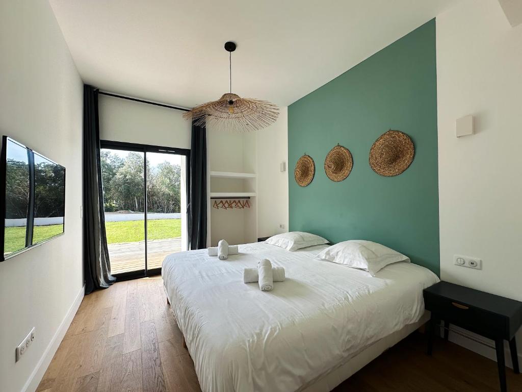 a bedroom with a large bed with two candles on it at Villas de standing avec magnifique vue mer et piscines privées, Sagone in Sagone
