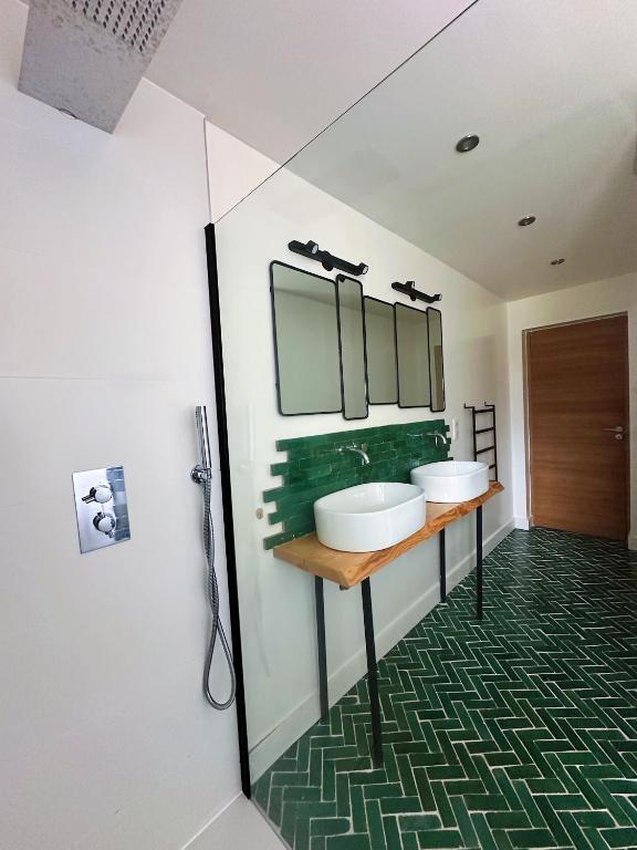 a bathroom with two sinks and a mirror at Villas de standing avec magnifique vue mer et piscines privées, Sagone in Sagone
