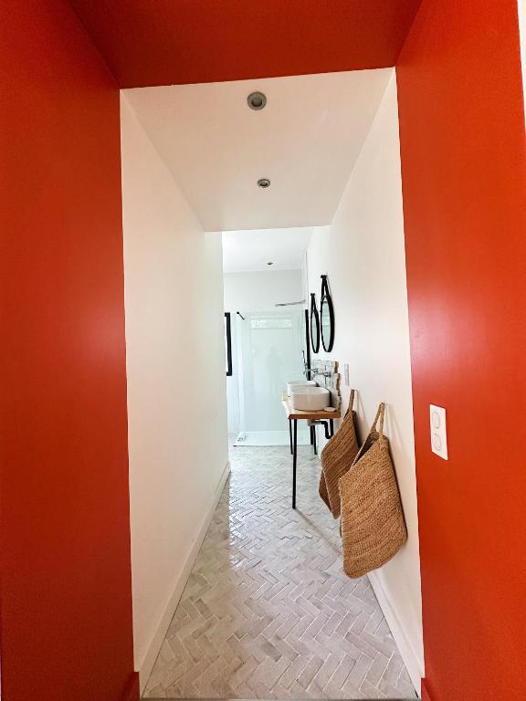 a hallway with orange and white walls and a table at Villas de standing avec magnifique vue mer et piscines privées, Sagone in Sagone