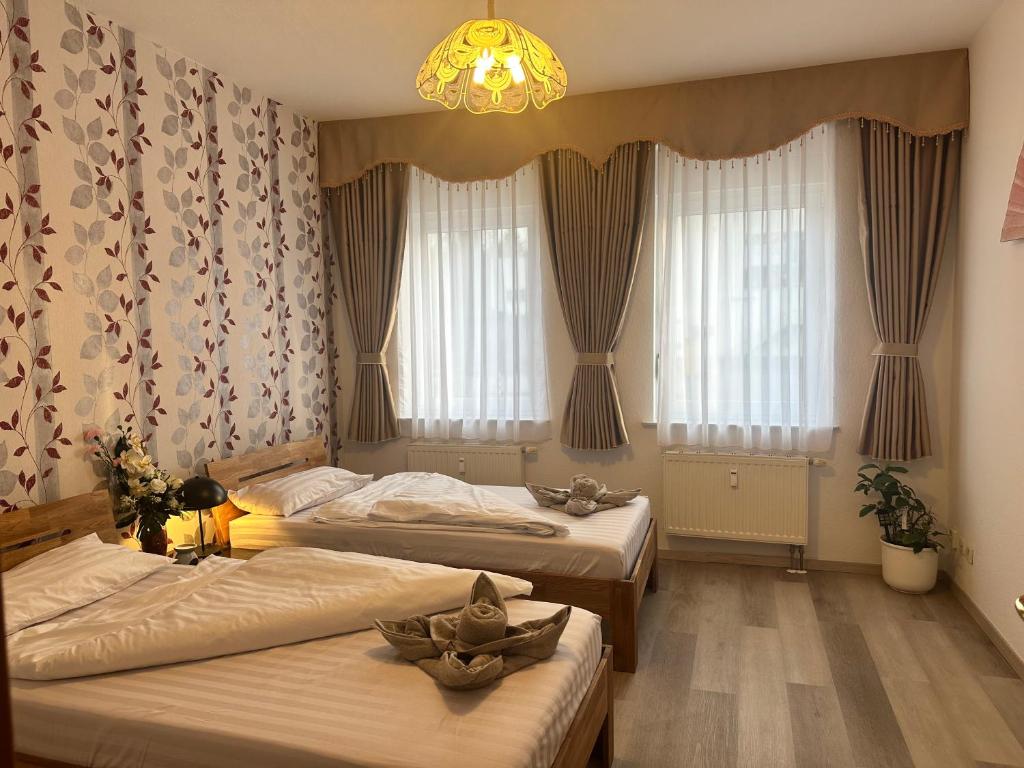 1 dormitorio con 2 camas y lámpara de araña en Käthe-Kollwitz Straße 54, F1, en Altemburgo