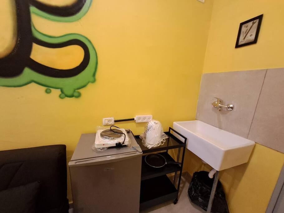 ein Badezimmer mit einem Waschbecken und einer Theke mit einem Waschbecken in der Unterkunft Fellini Nine ground (talpiot) in Haifa