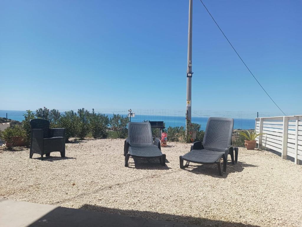 trzy krzesła siedzące na piasku blisko oceanu w obiekcie Casa vacanze Abbacari w mieście Realmonte