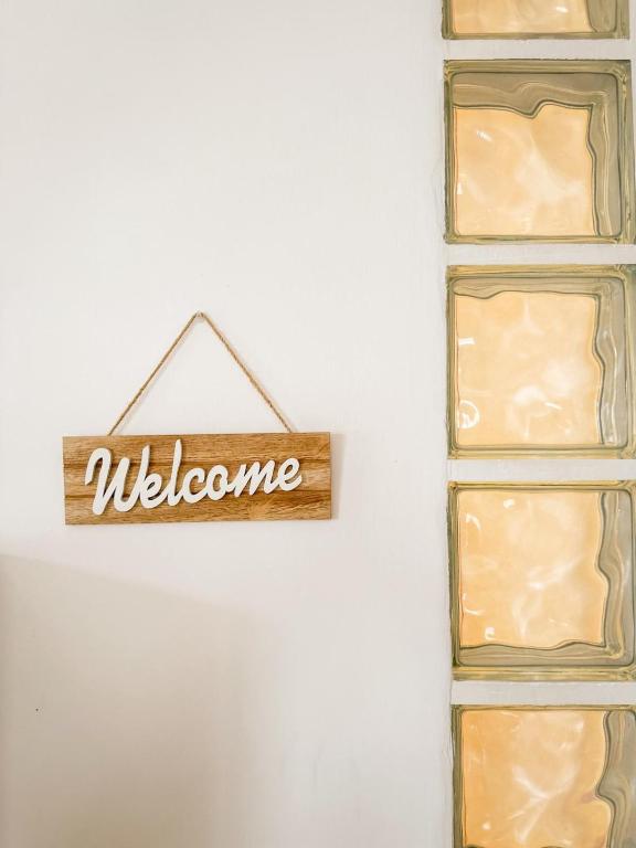 a sign that reads welcome hanging on a wall at La casa di Lory in Falconara Marittima