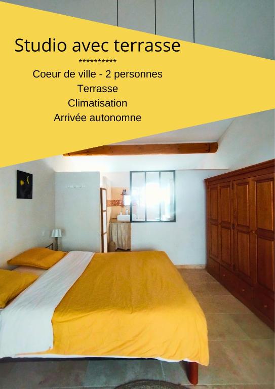 une chambre avec un grand lit avec une couverture jaune dans l'établissement Studio en plein coeur du village, à Beaumes-de-Venise
