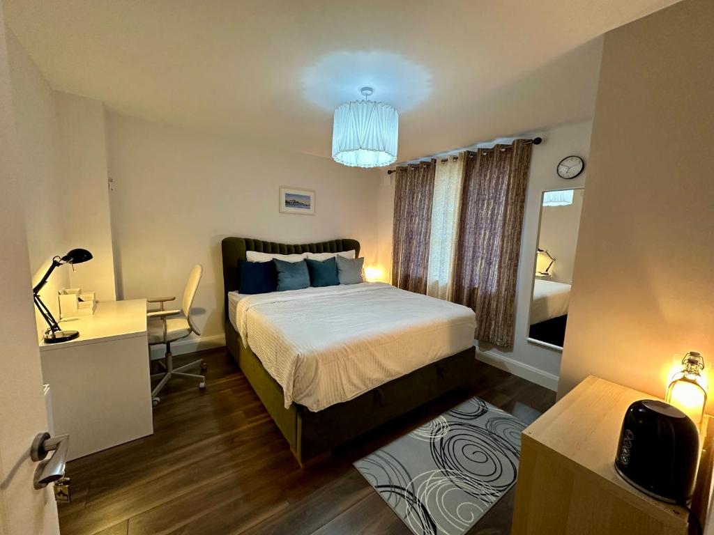 een slaapkamer met een bed en een bureau met een lamp bij Big Cozy Room near City Center in Dublin