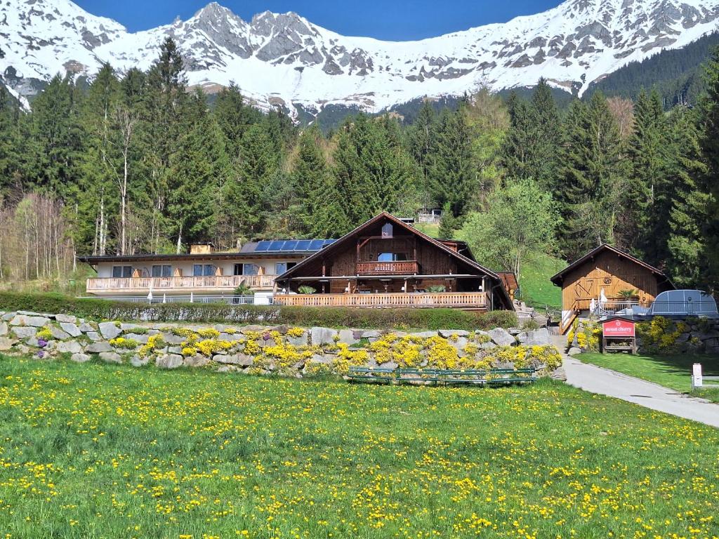 a house in a field with mountains in the background at Sweet Cherry - Boutique &amp; Guesthouse Tyrol in Innsbruck