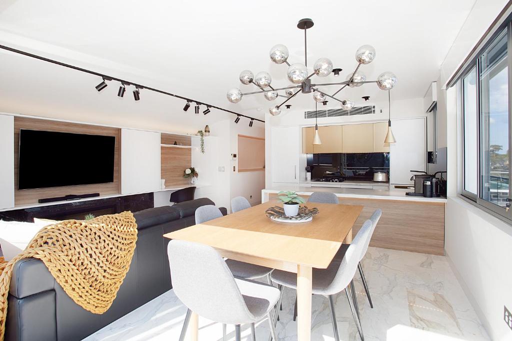 een eetkamer en een woonkamer met een tafel en stoelen bij Perfect Located 2-Bed with Spacious Balcony & BBQ in Sydney