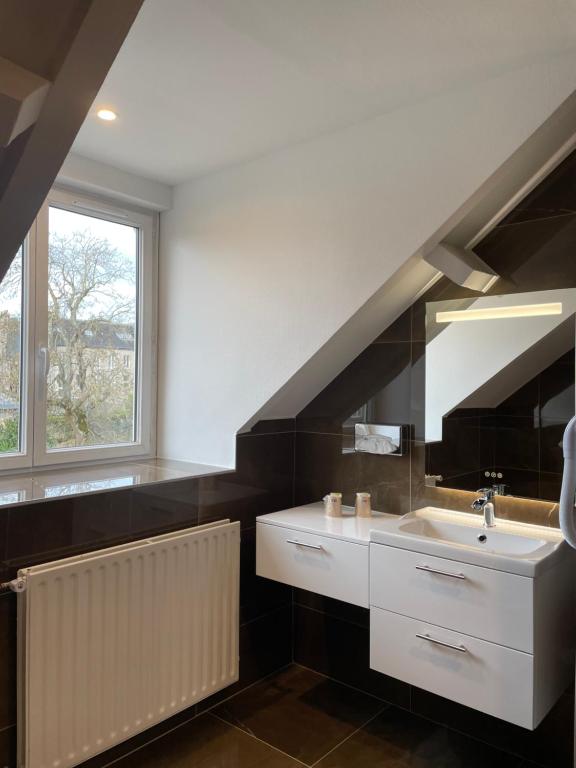a bathroom with a sink and a staircase at Hotel Le Cercle in Cherbourg en Cotentin