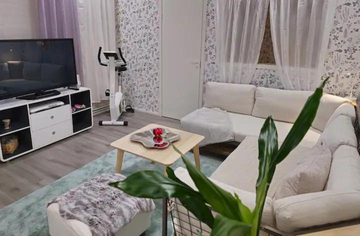 a living room with a white couch and a table at Karlabacken in Porvoo