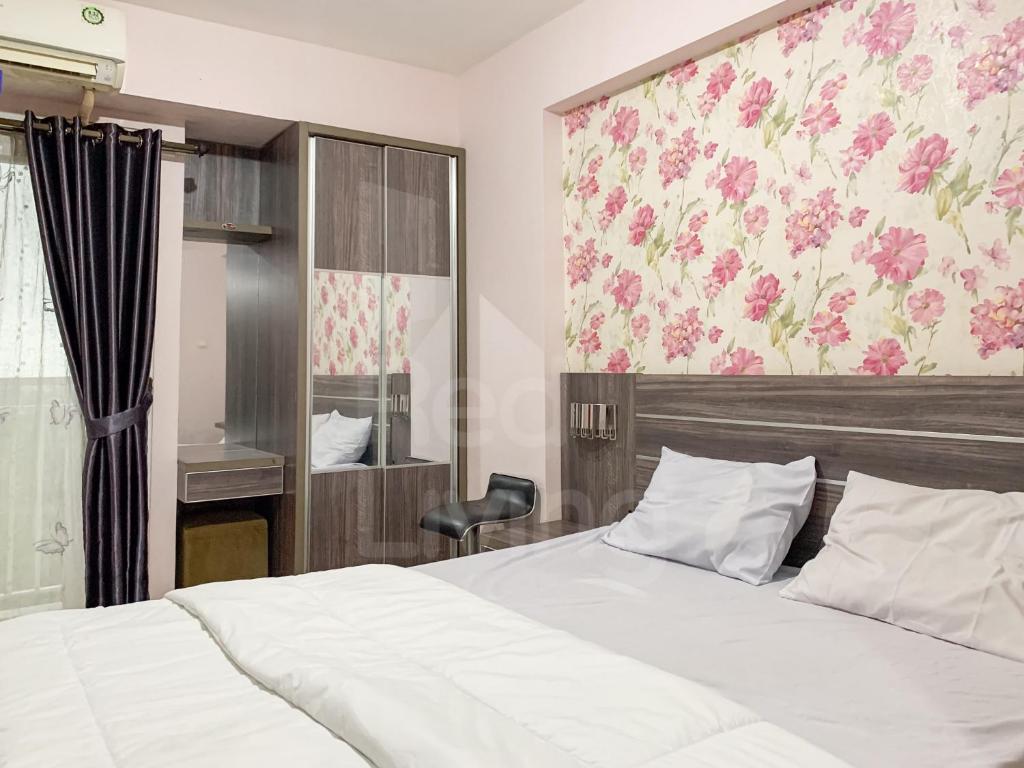 - une chambre avec un lit et un papier peint floral dans l'établissement RedLiving Apartemen Bogor Valley - Paulina Property Tower A, à Kalibata 1