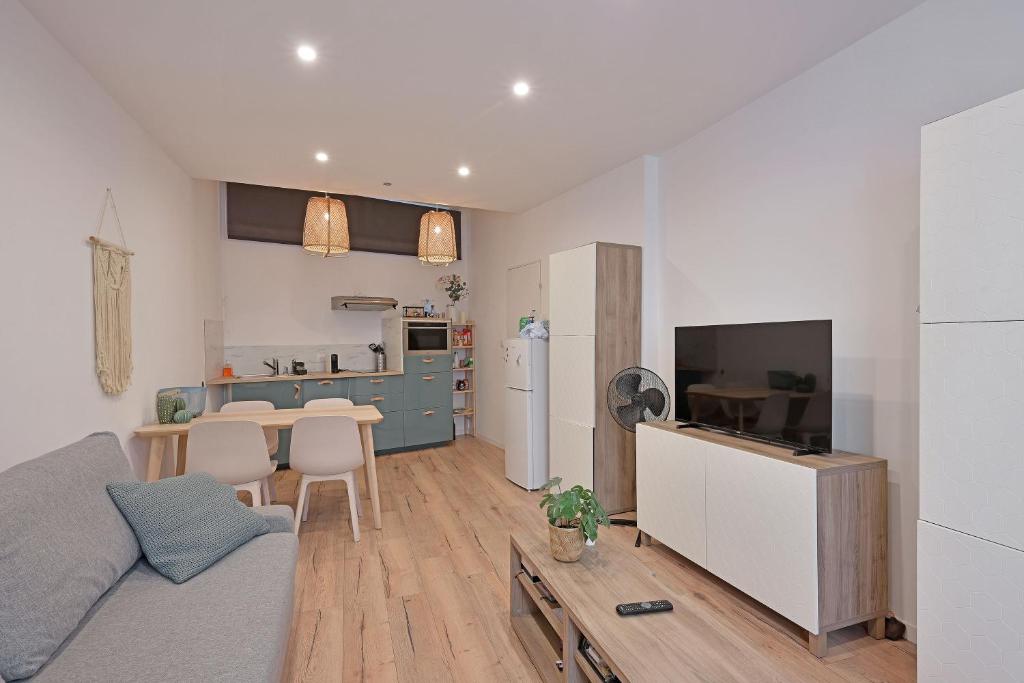 una cucina e un soggiorno con un divano e un tavolo di Studio Andréa - Proche Théatres et Place des corps saints - WIFI ad Avignone