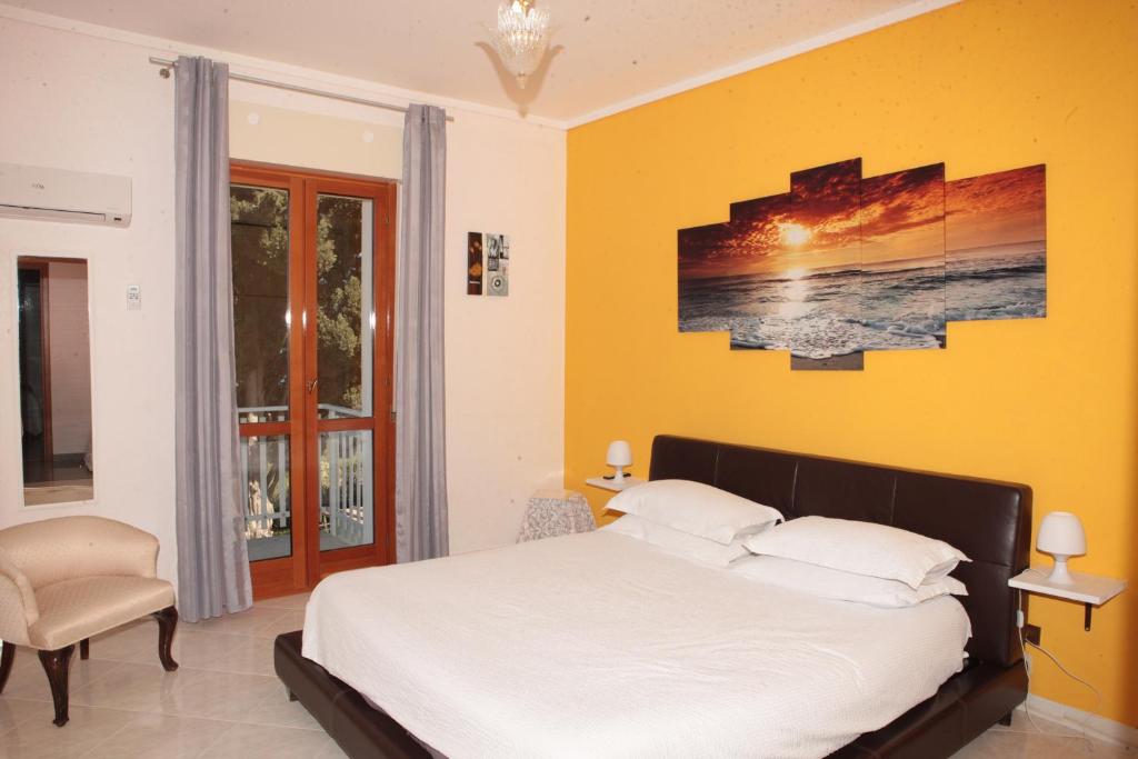 a bedroom with a bed and a yellow wall at Dream on the Blue House in Valderice