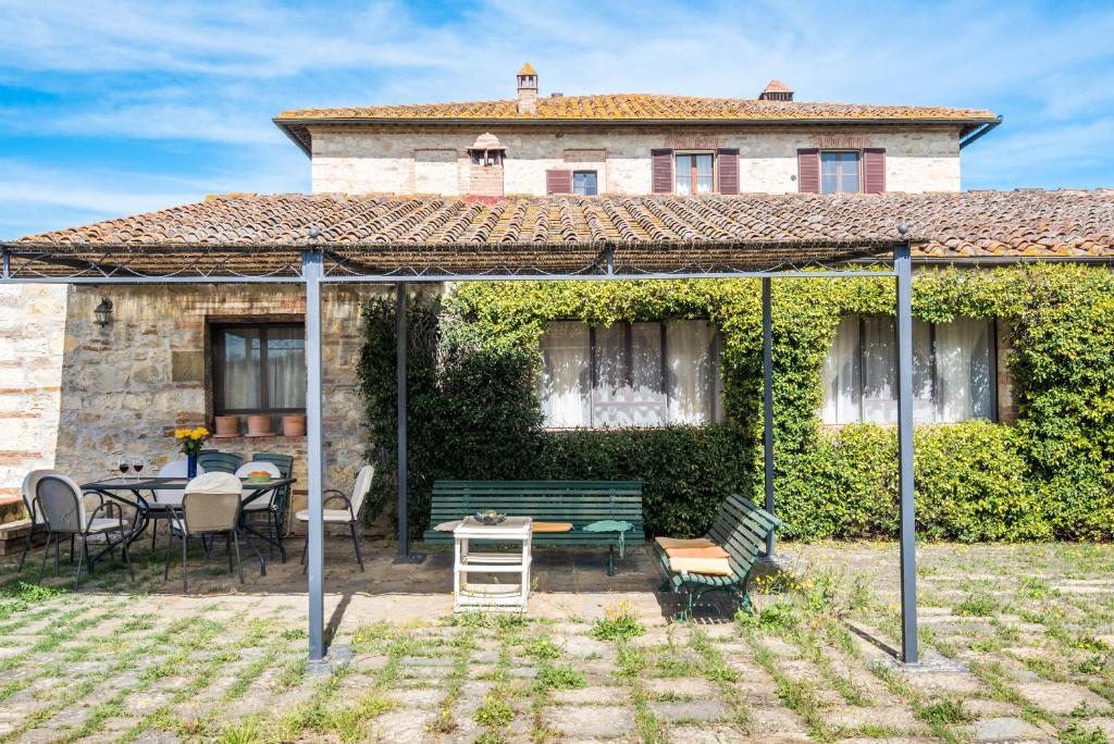 a patio with a table and chairs in front of a building at Casalino in Castelnuovo Berardenga