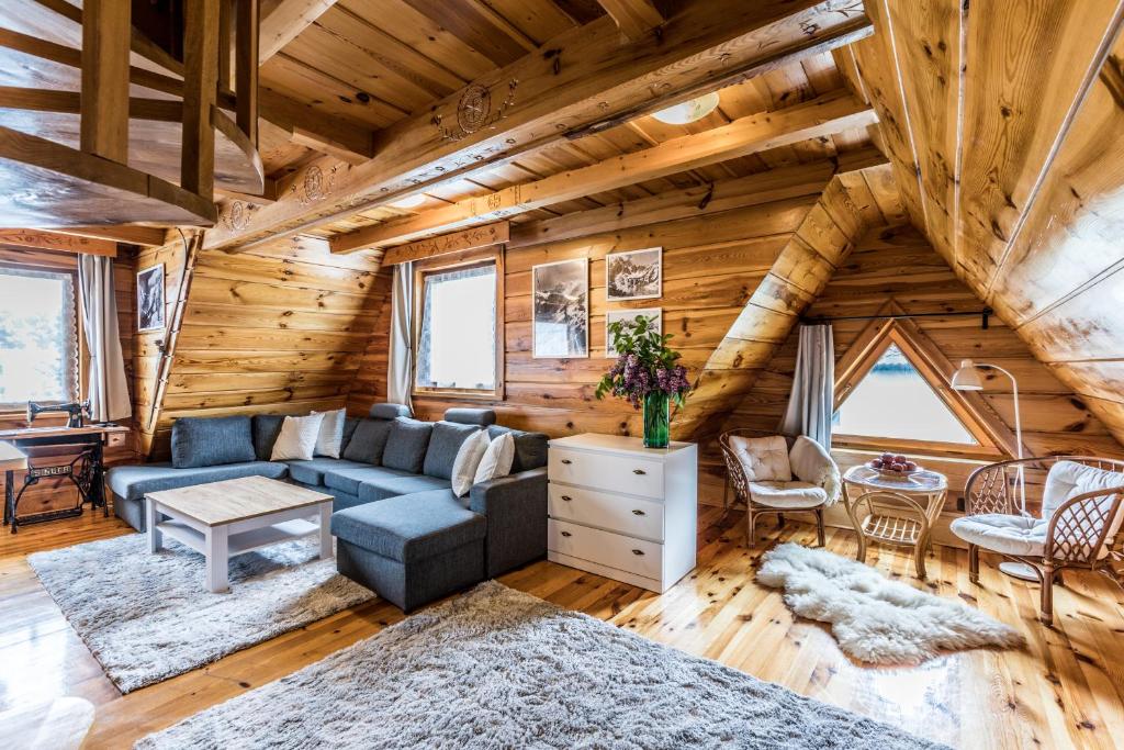 a living room with a blue couch in a log cabin at Apartament Nosalowy in Zakopane