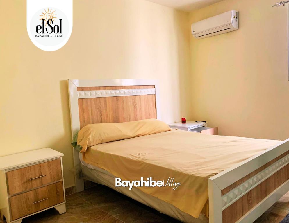 1 dormitorio con 1 cama con cabecero de madera en El Sol ※ Bayahibe Village en Bayahibe