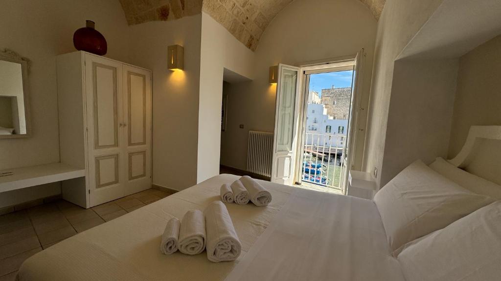 Residenza Garibaldi في مونوبولي: غرفة نوم عليها سرير وفوط بيضاء